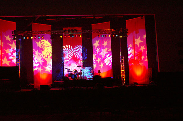 A stage set up for a concert with multi-colored stars and swirls